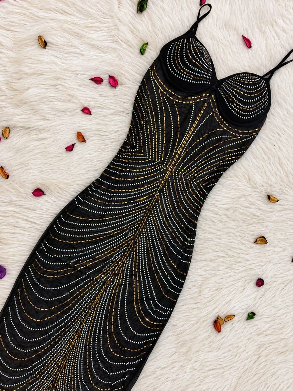 Black embellished lingerie dress arranged on ivory fur